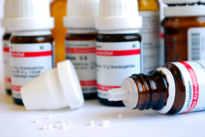 close-up of homeopathic globule with medicine bottles